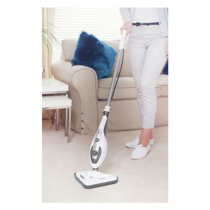 A person using a steam cleaner on a carpet in a home