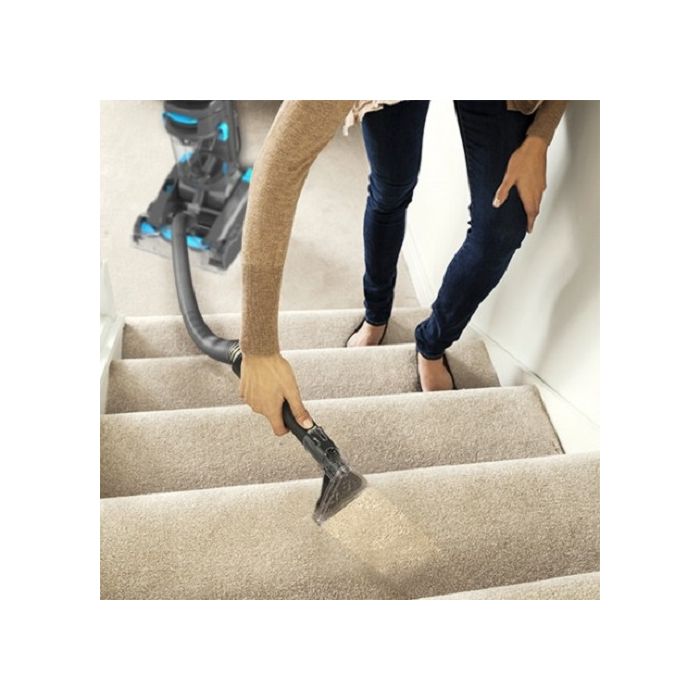 The VAX dual power lightweight upright carpet cleaner being used on a staircase